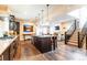 Open kitchen featuring a large island, stainless steel appliances, and seamless flow into the living area and stairs at 1152 S Ogden St, Denver, CO 80210