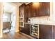 Stylish kitchenette with dark wood cabinets, stainless steel appliances and a beverage fridge at 1152 S Ogden St, Denver, CO 80210