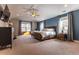 Comfortable main bedroom with a king bed, blue accent wall, and large windows with natural light at 1152 S Ogden St, Denver, CO 80210