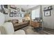 Cozy living room with hardwood floor, tan couch, and numerous decorative pictures and shelves at 20 Vista Canyon Dr, Castle Rock, CO 80104