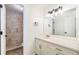 Bathroom vanity with a large mirror adjacent to a tiled walk-in shower at 5145 W 61St Dr # 14, Arvada, CO 80003