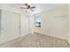 Neutral bedroom with a ceiling fan, window, and closet with white sliding doors at 5145 W 61St Dr # 14, Arvada, CO 80003
