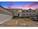 Two story home showcasing beautiful landscaping and a shared parking area at dusk at 5145 W 61St Dr # 14, Arvada, CO 80003