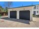 Two-car garage with black doors and a paved driveway, close to the home at 5145 W 61St Dr # 14, Arvada, CO 80003