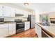 Bright kitchen with stainless steel appliances, white cabinets, and wood flooring at 5145 W 61St Dr # 14, Arvada, CO 80003