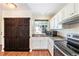 Kitchen with white cabinets, dark countertops, and a rustic barn door detail at 5145 W 61St Dr # 14, Arvada, CO 80003