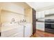 Laundry area with appliances, white cabinetry, and a unique dark wood door detail at 5145 W 61St Dr # 14, Arvada, CO 80003