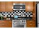 Modern kitchen featuring black and white checkered backsplash and stainless-steel appliances at 2001 Lincoln St # 2412, Denver, CO 80202