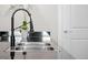 Close-up of a stainless steel kitchen sink with modern fixtures and a black countertop at 2001 Lincoln St # 2412, Denver, CO 80202