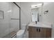 Modern bathroom featuring a glass shower and wood vanity with modern fixtures at 1372 Lowell Blvd # 1, Denver, CO 80204