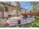 Back patio features a barbecue grill, outdoor dining set, and lounging area with a privacy fence at 16376 Flintlock Ct, Parker, CO 80134