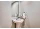 Stylish powder room features a pedestal sink, elegant mirror, and neutral wall color at 16376 Flintlock Ct, Parker, CO 80134