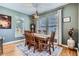 Cozy dining room with a large wooden table, chandelier, and views of the backyard at 16376 Flintlock Ct, Parker, CO 80134