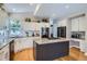 Modern kitchen featuring white cabinets, granite countertops, stainless steel appliances, and a center island at 16376 Flintlock Ct, Parker, CO 80134