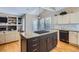Spacious kitchen island with granite countertop and black cabinets at 16376 Flintlock Ct, Parker, CO 80134