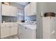 Functional laundry room equipped with white cabinets, a sink, and a modern washer and dryer set at 16376 Flintlock Ct, Parker, CO 80134