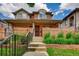 Brick house with front yard, landscaping, metal fence and concrete steps at 536 Cook St, Denver, CO 80206