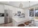 Modern kitchen with a quartz countertop island, stainless steel appliances, and a mosaic tile backsplash at 753 Audubon Peak Dr, Erie, CO 80516