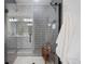 Modern glass shower with gray subway tile, bench, and hexagon tile floor, creating a spa-like bathroom experience at 753 Audubon Peak Dr, Erie, CO 80516