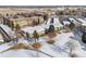 An aerial view shows the community landscaping including bare trees, an ice rink, and adjacent covered parking at 9320 E Center Ave # 4B, Denver, CO 80247