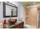 Stylish bathroom features glass bowl sink, granite countertop, and tiled walk-in shower at 9320 E Center Ave # 4B, Denver, CO 80247
