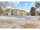 Low-angle view of the tan building at 6320 with a snow-covered yard in front on a beautiful sunny day at 9320 E Center Ave # 4B, Denver, CO 80247