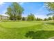 Expansive green lawn with mature trees and a golf green creating a picturesque landscape at 9320 E Center Ave # 4B, Denver, CO 80247