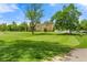 Well-manicured green lawn with mature trees and a golf green, providing a picturesque setting at 9320 E Center Ave # 4B, Denver, CO 80247