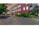 Modern apartment building exterior with colorful accents, mature landscaping, and convenient parking at 1521 Central St # 2D, Denver, CO 80211