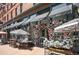 Quaint café exterior with floral archway, striped awnings, inviting outdoor seating and curb appeal at 1521 Central St # 2D, Denver, CO 80211
