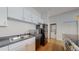 Kitchen with a sink, appliances, white cabinets, and washer/dryer laundry closet at 1521 Central St # 2D, Denver, CO 80211