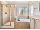 Bright bathroom featuring a shower, tub, and natural light at 10201 Rifle St, Commerce City, CO 80022