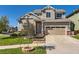 Two-story home with a beige exterior, well-kept lawn, and mature landscaping, creating a welcoming curb appeal at 10201 Rifle St, Commerce City, CO 80022