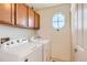 Bright laundry room with washer, dryer, and storage cabinets at 10201 Rifle St, Commerce City, CO 80022