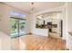 Open-concept living room with hardwood floors and sliding glass doors to backyard with partial kitchen view at 10201 Rifle St, Commerce City, CO 80022