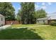 Spacious backyard features lush green lawn, wooden fence, storage shed, and mature trees offering shade at 1712 S Gilpin St, Denver, CO 80210