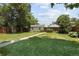 Green backyard with lush lawn, walkway to detached garage, and tall privacy fence at 1712 S Gilpin St, Denver, CO 80210