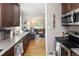 Open concept kitchen flowing into the living area, featuring stainless steel appliances and wood floors at 1712 S Gilpin St, Denver, CO 80210