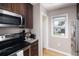 Modern kitchen with stainless steel microwave and stove, granite counters, and wood cabinets at 1712 S Gilpin St, Denver, CO 80210