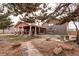 Charming home exterior features a covered patio and lush yard, perfect for relaxing and entertaining at 3820 S Ames St, Denver, CO 80235