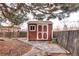Backyard shed with double doors and window offers secure storage and complements the fenced yard at 3820 S Ames St, Denver, CO 80235