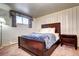 Cozy bedroom with wood-framed bed and nightstand features patterned wallpaper and carpet for a warm feel at 3820 S Ames St, Denver, CO 80235