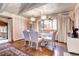 Bright dining room features hardwood floors, chandelier, and a large window with curtains at 3820 S Ames St, Denver, CO 80235