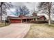 Charming single-story brick home with a well-manicured lawn and a spacious driveway leading to an attached garage at 3820 S Ames St, Denver, CO 80235