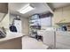 Functional laundry room equipped with washer, dryer, utility sink, and ample storage shelving at 3820 S Ames St, Denver, CO 80235