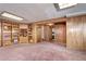 A spacious living area with paneled walls, soft carpeting, and convenient built-in shelving units at 3820 S Ames St, Denver, CO 80235