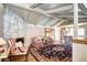 Bright living room boasts stone fireplace, beamed ceilings, and hardwood floors at 3820 S Ames St, Denver, CO 80235