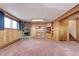 Living room features a cozy stone fireplace, wood paneling, plush carpeting, and built-in wooden shelves at 3820 S Ames St, Denver, CO 80235