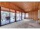 Wood paneled sun room featuring large glass sliding doors and backyard patio access at 3820 S Ames St, Denver, CO 80235