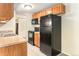 Functional kitchen features black appliances, wooden cabinets, and tile flooring at 2375 S Linden Ct # 201, Denver, CO 80222
